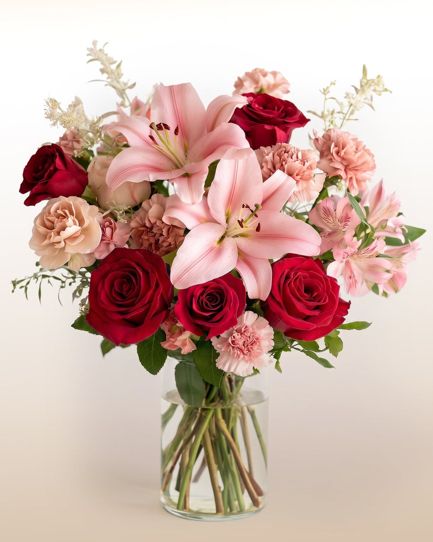 Rosas rojas, lirios rosados y alstroemerias en un ramo romántico y expresivo. Dile "me enamoras" con flores. Entrega el mismo día.