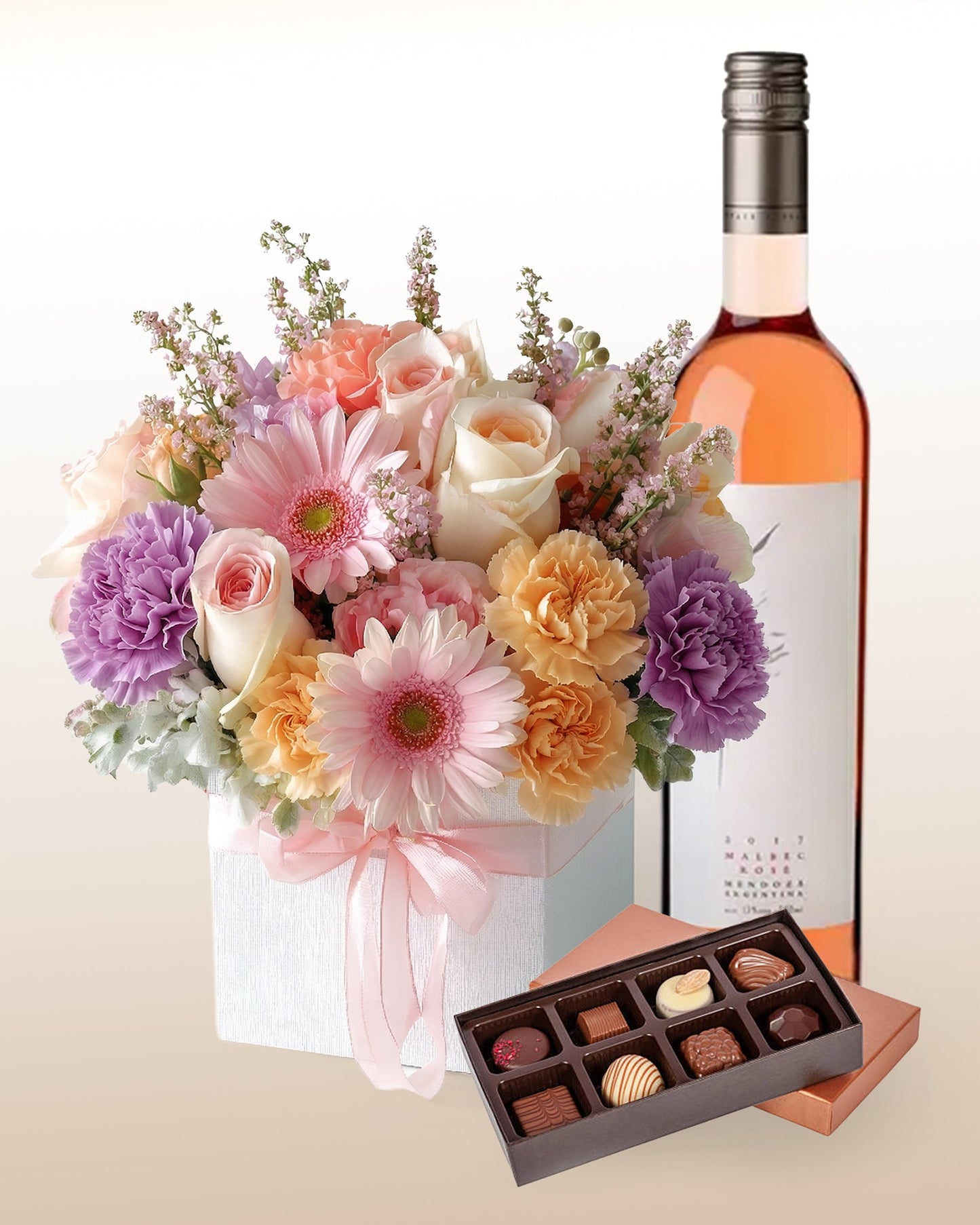 Flores en tonos suaves, vino rosé y chocolates. Un regalo completo para disfrutar sin pensar. Envío a domicilio.