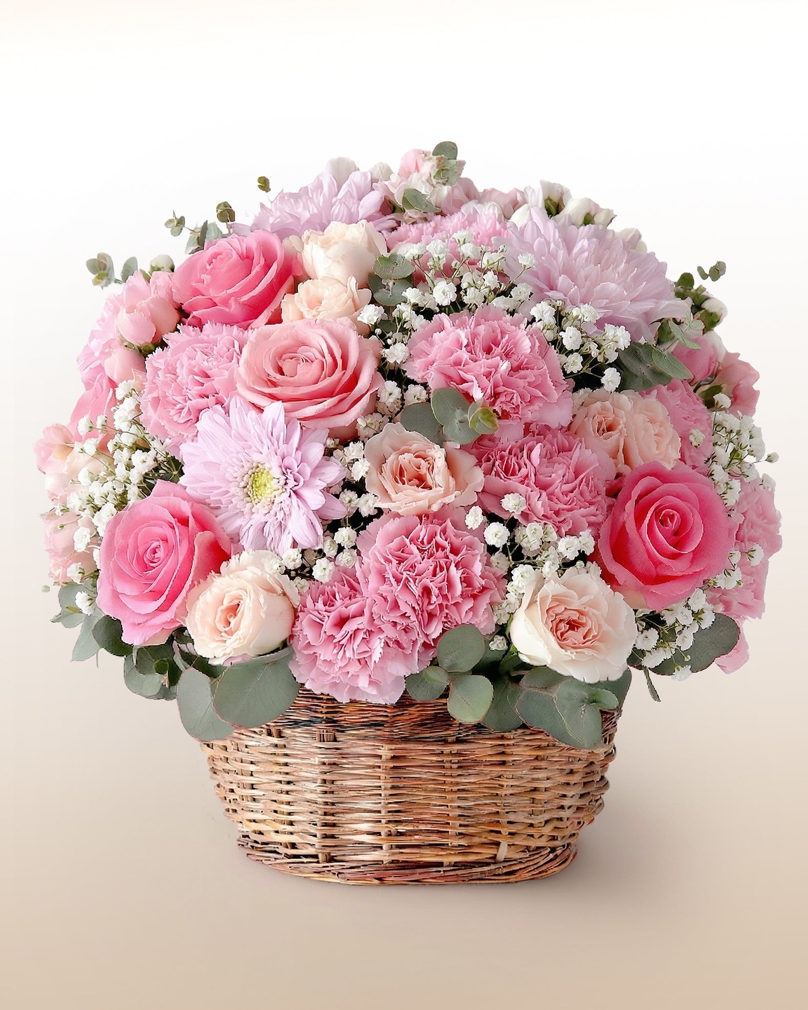 Canasta con rosas, claveles y gerbera en tonos rosados. Un arreglo abundante para hacer sentir especial a alguien. Envío a domicilio.